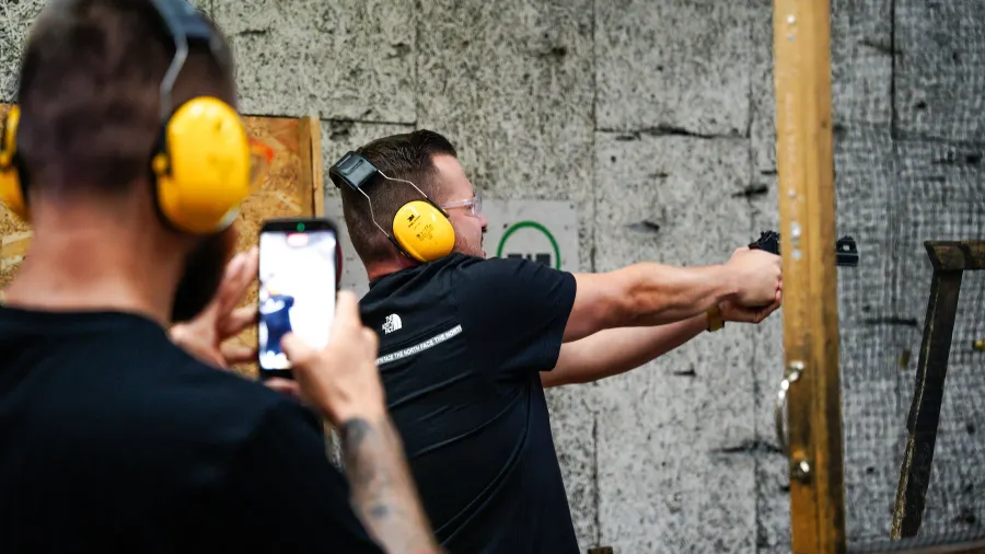 Az oktató telefonnal videózza a célzó vendéget